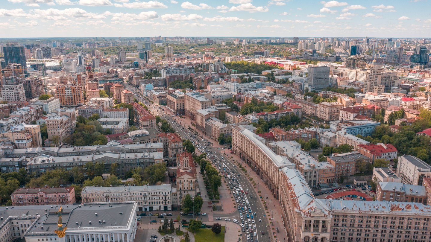 Heavy traffic flows through a dense city center with diverse buildings.