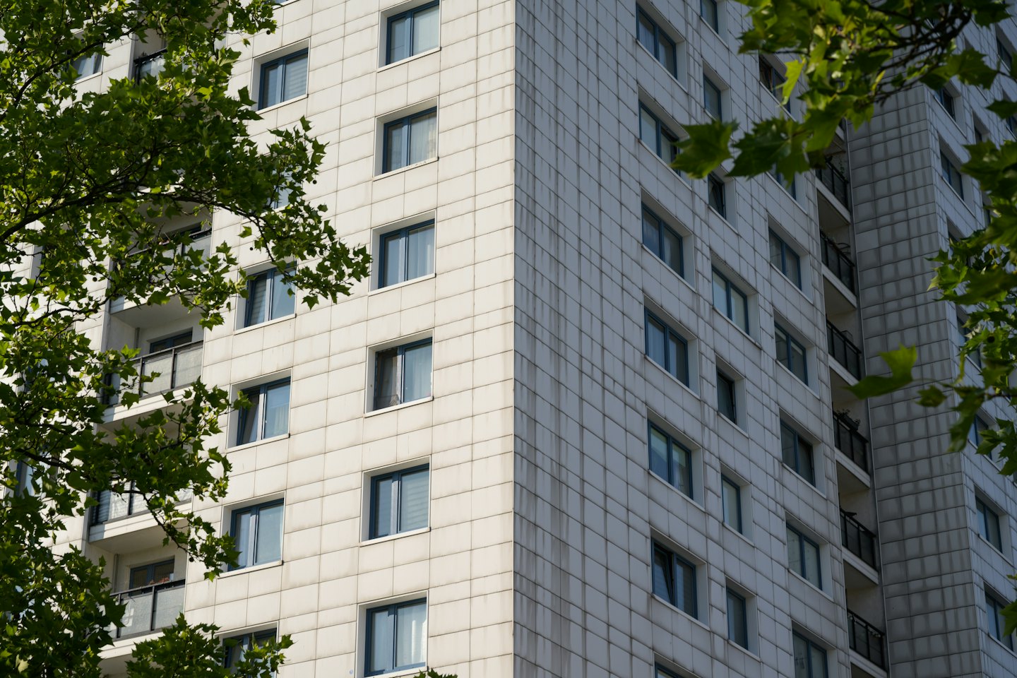 Modern multi-story apartment building with balconies and paneled exterior walls.